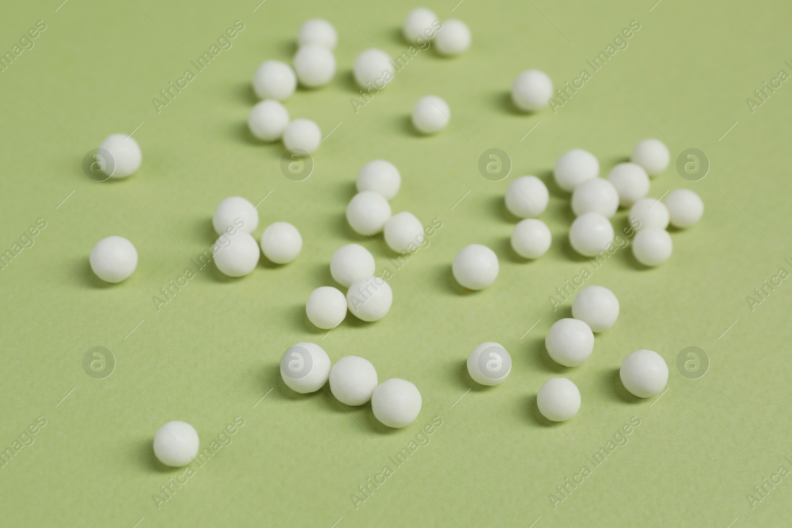 Photo of Homeopathic remedy on light green background. Alternative medicine