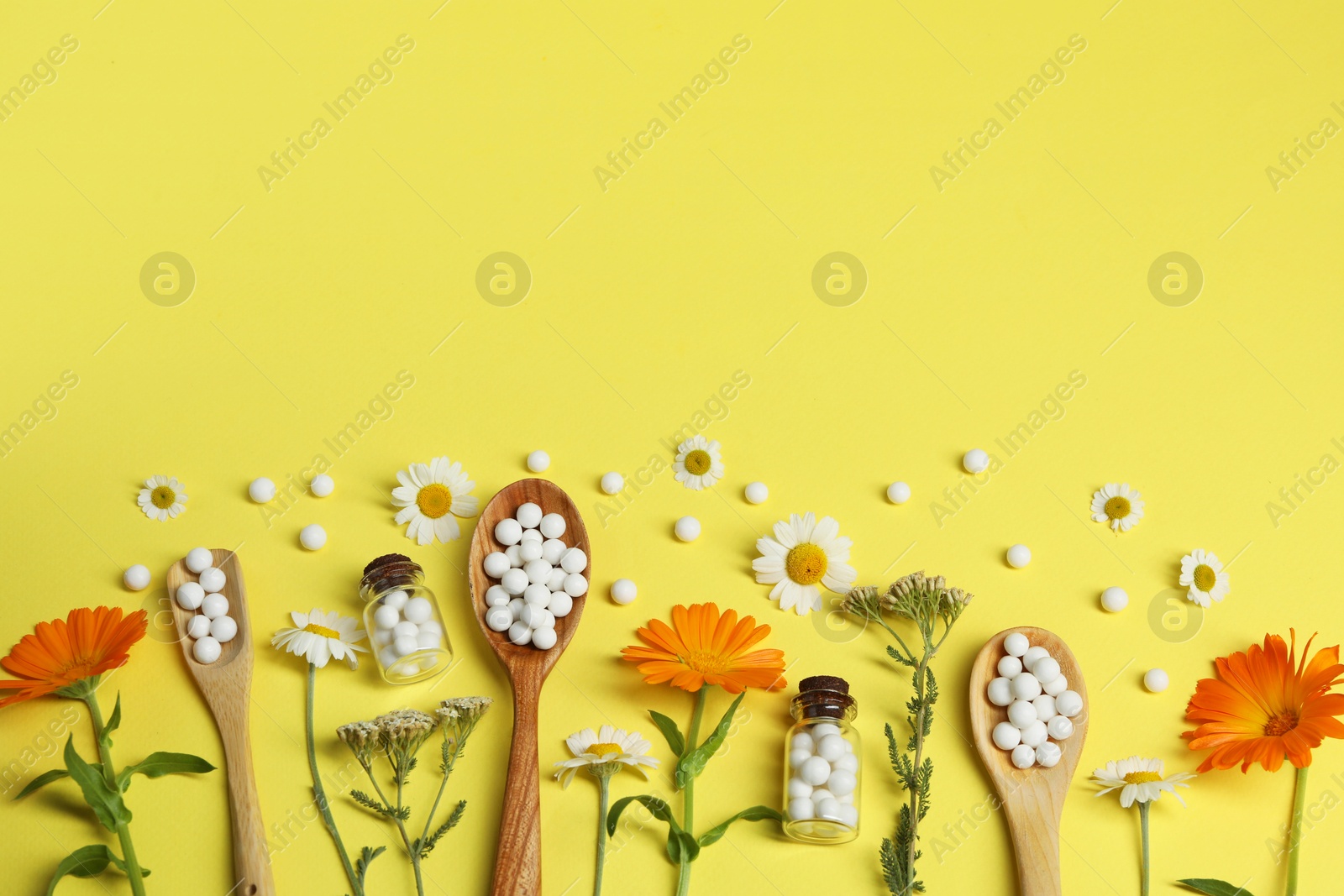 Photo of Flat lay composition with homeopathic remedy and flowers on yellow background. Space for text