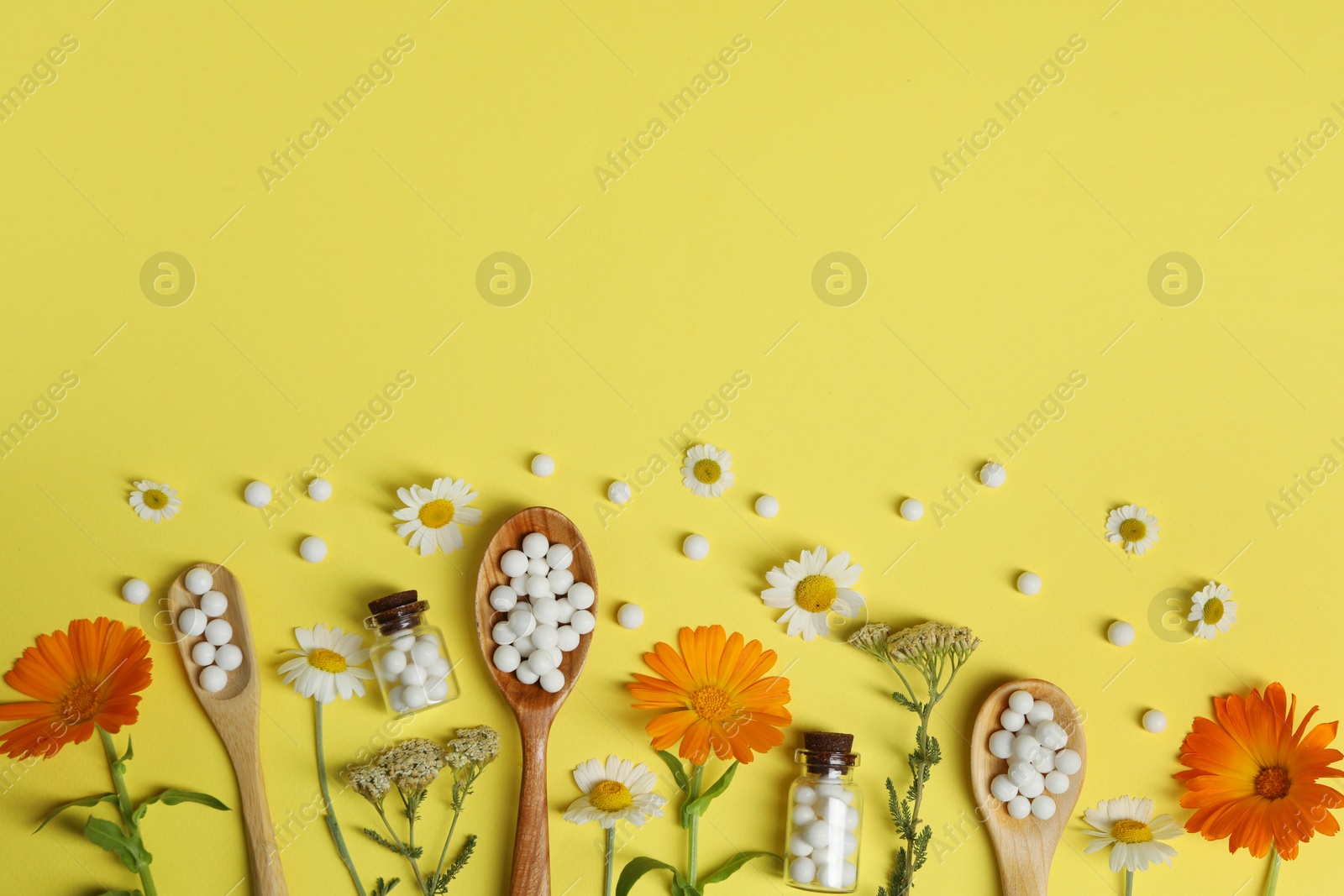 Photo of Flat lay composition with homeopathic remedy and flowers on yellow background. Space for text