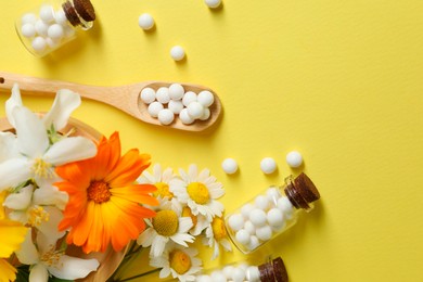 Photo of Homeopathic remedy and flowers on yellow background, flat lay. Space for text