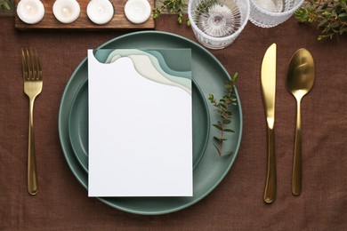 Photo of Empty menu, plates, cutlery, glasses and decor on table, top view. Mockup for design