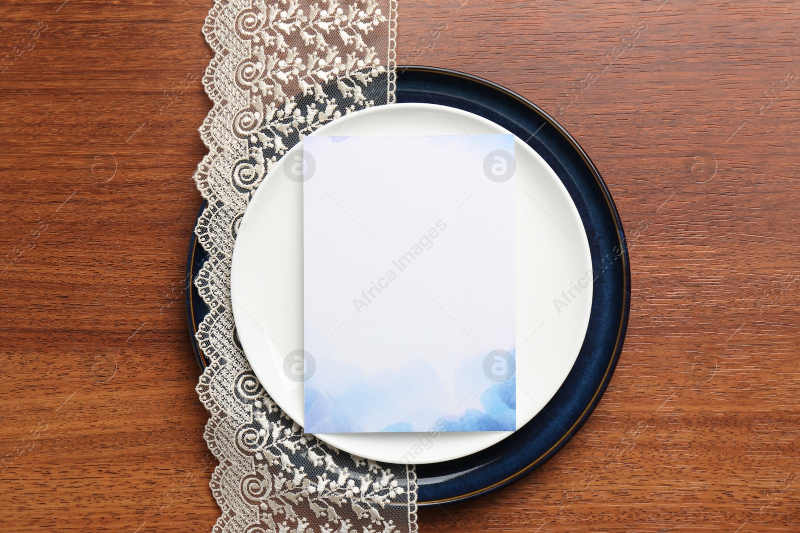 Photo of Empty menu and plates on wooden table, top view. Mockup for design