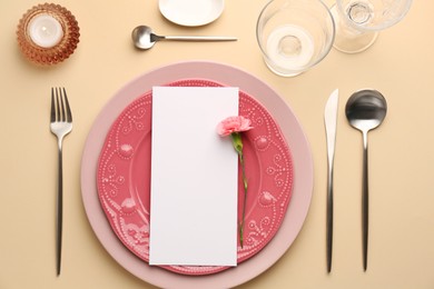 Empty menu, tableware, candle and floral decor on beige table, flat lay. Mockup for design