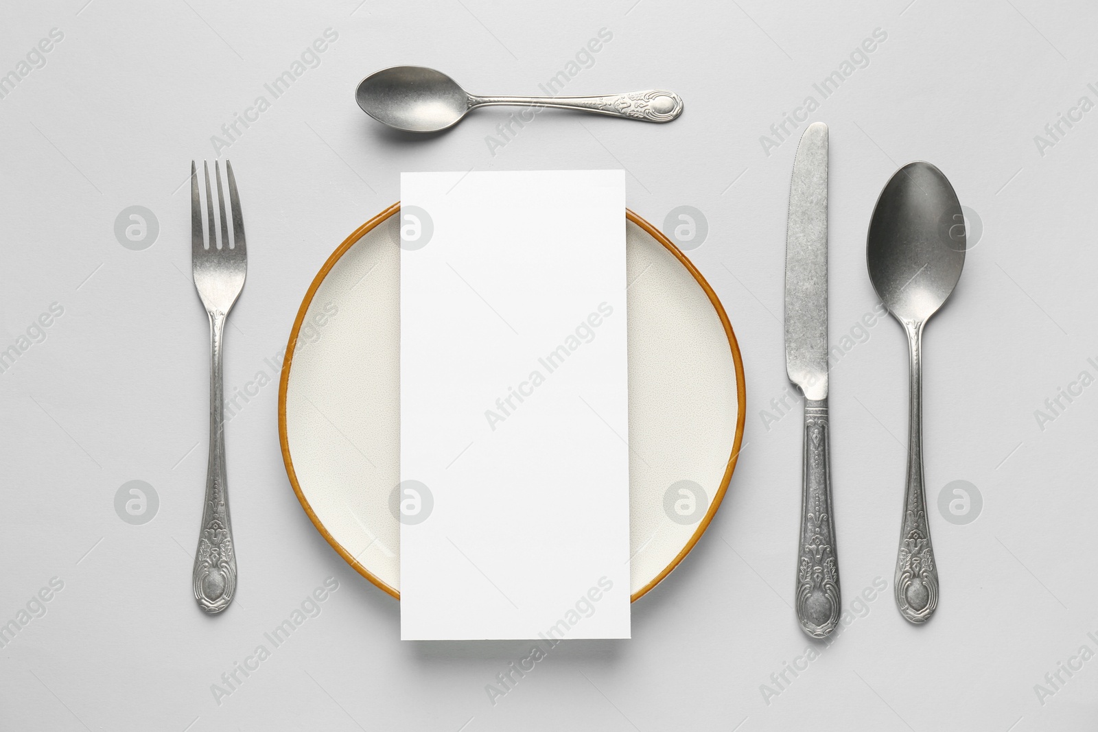 Photo of Empty menu, plate and cutlery on light grey background, flat lay. Mockup for design