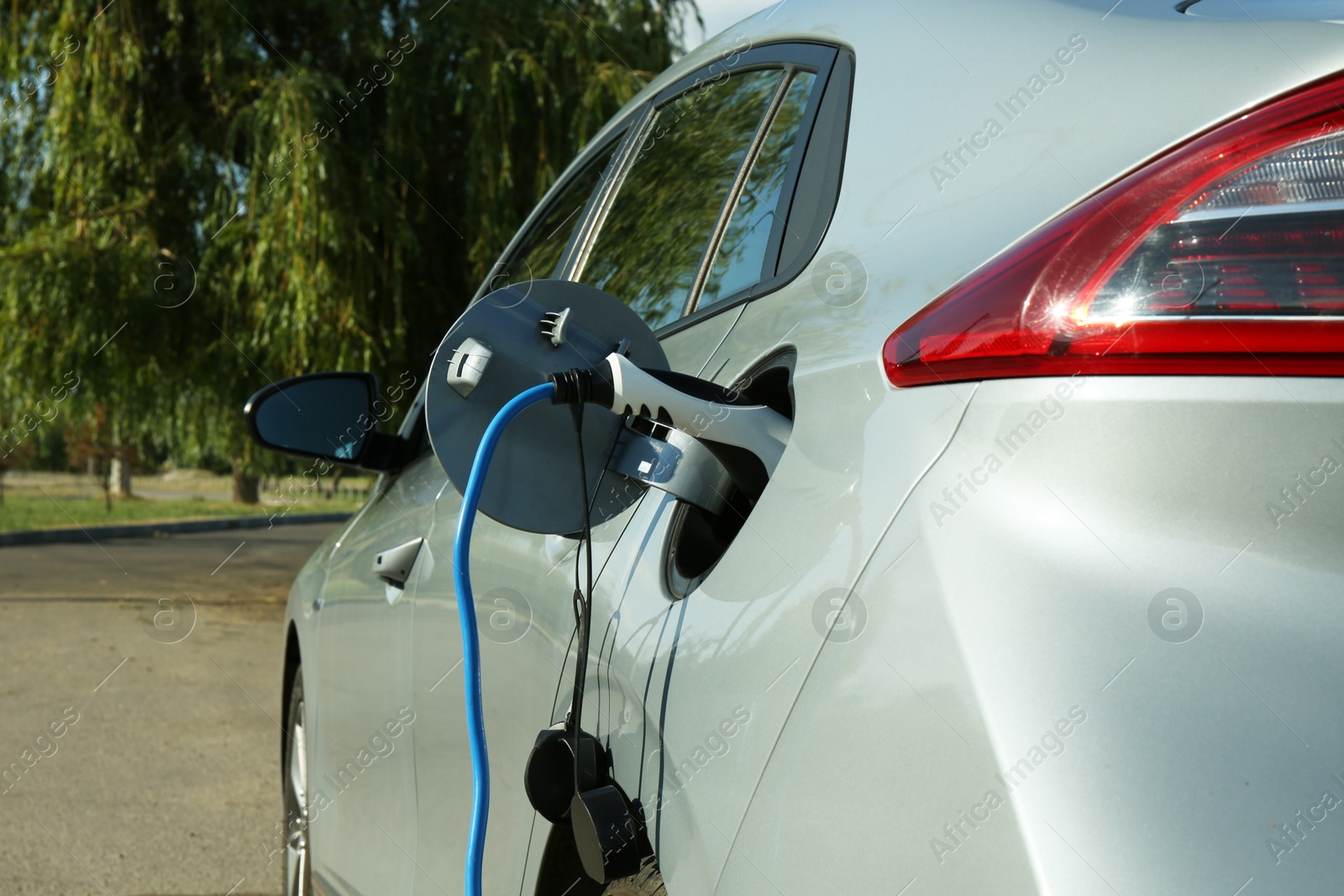 Photo of Charging modern electric car from station outdoors