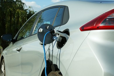 Charging modern electric car from station outdoors