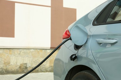 Photo of Modern electric car charging from station outdoors