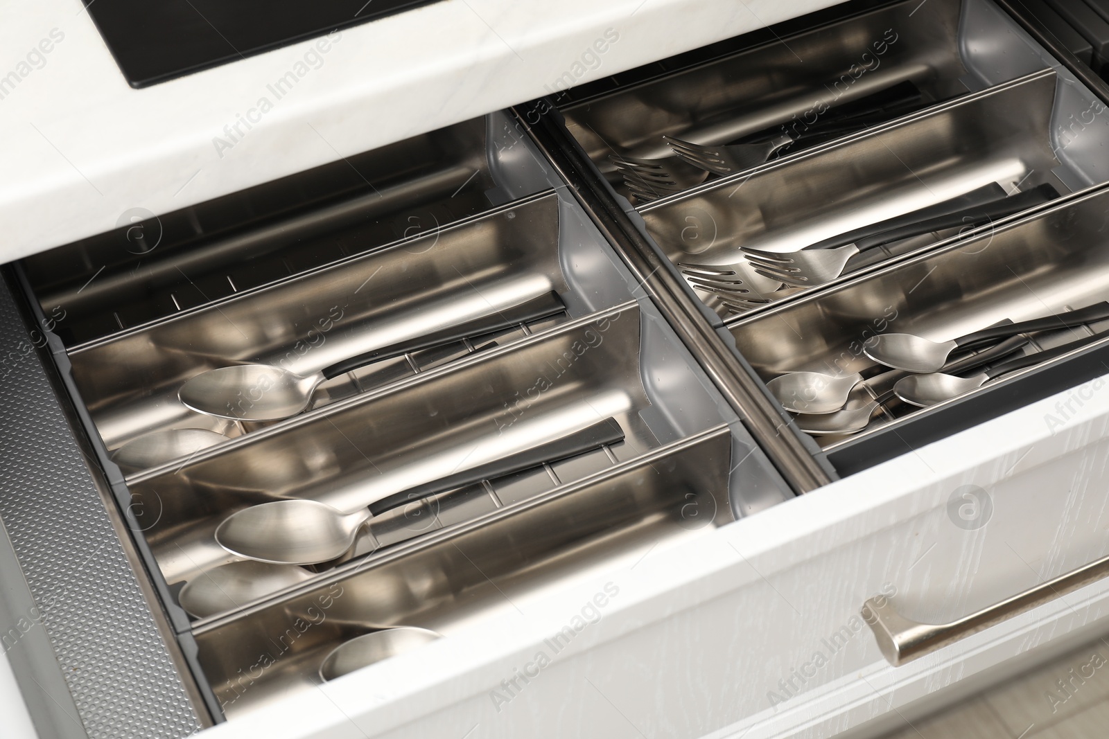 Photo of Box with cutlery in drawer, closeup. Kitchen utensils storage