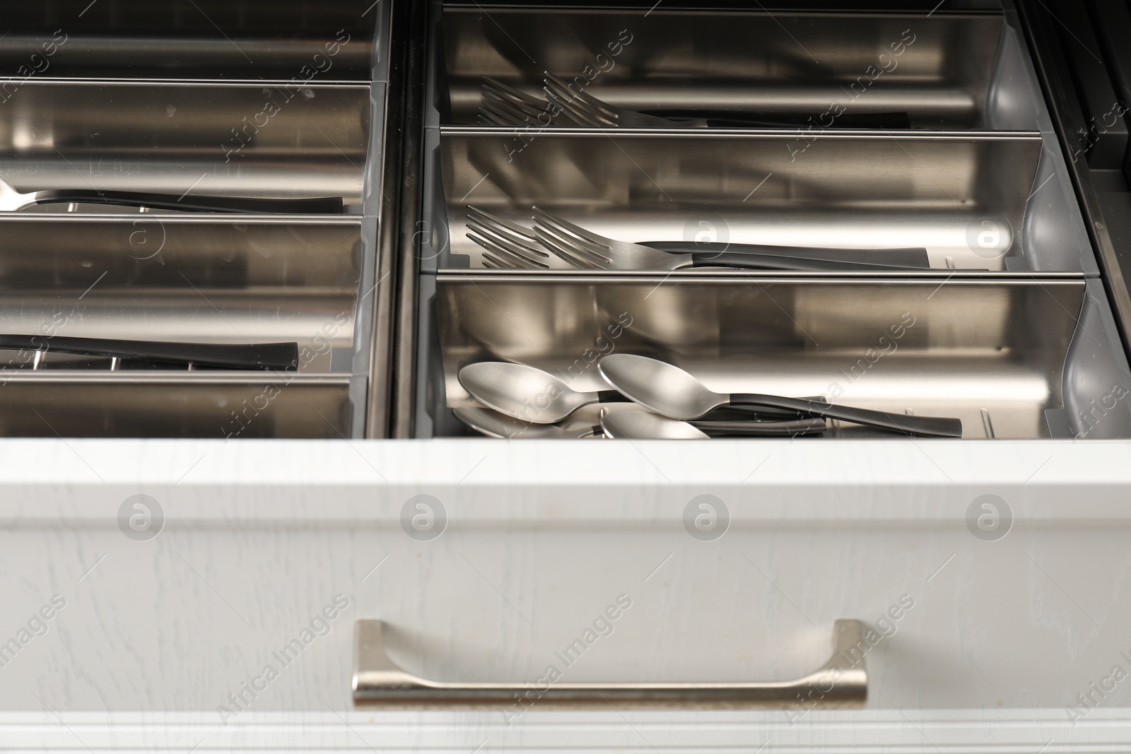 Photo of Box with cutlery in drawer, closeup. Kitchen utensils storage