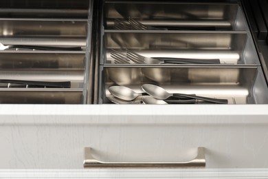 Box with cutlery in drawer, closeup. Kitchen utensils storage