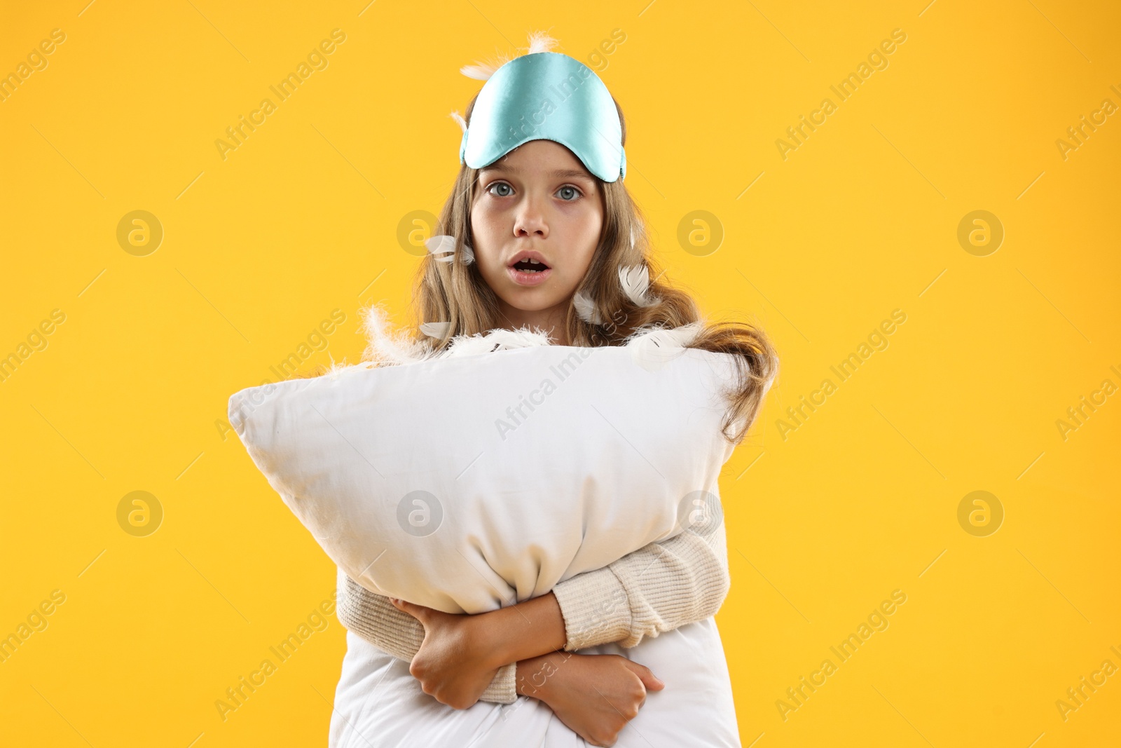 Photo of Overslept girl with sleep mask and pillow on orange background