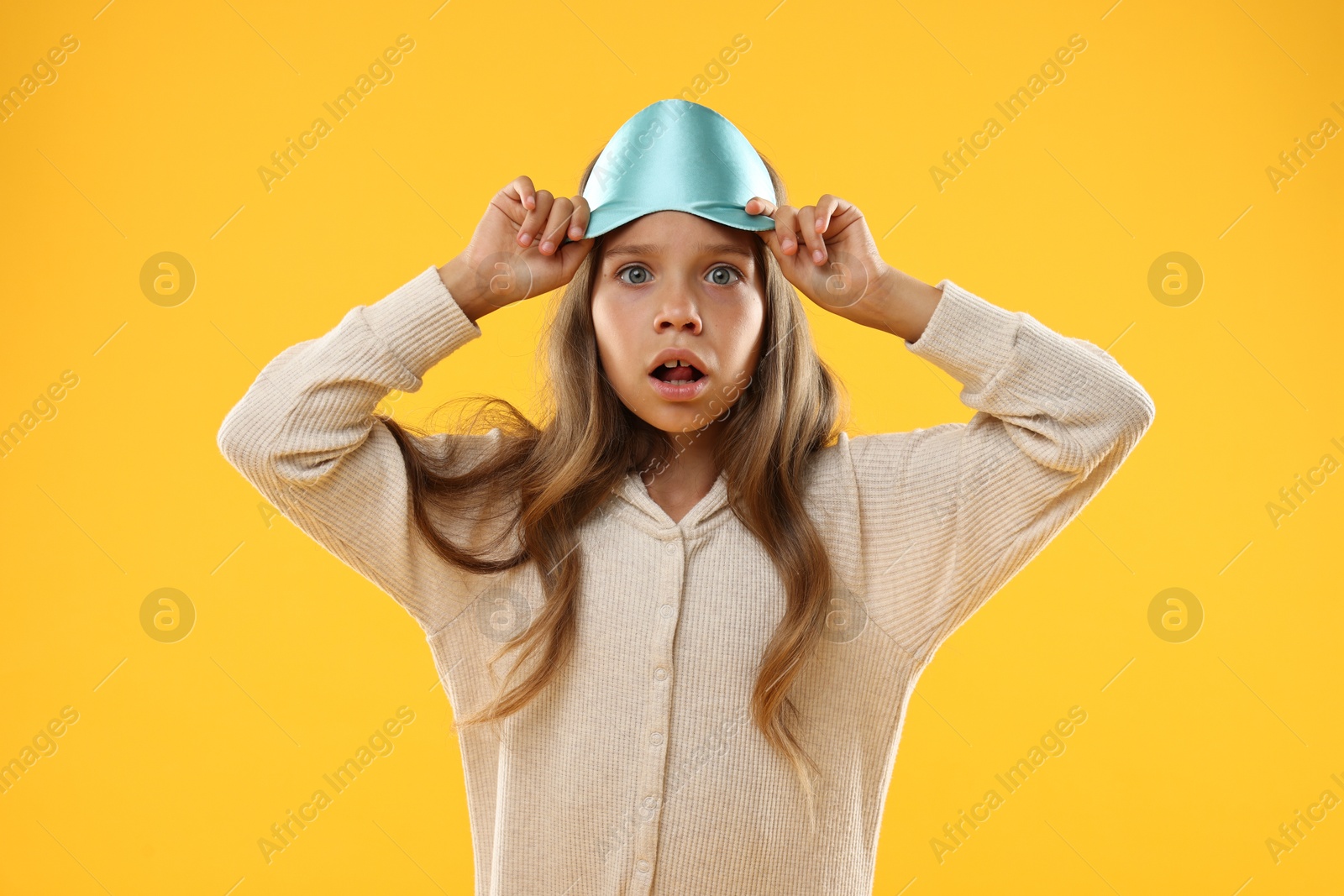 Photo of Overslept girl with sleep mask on orange background