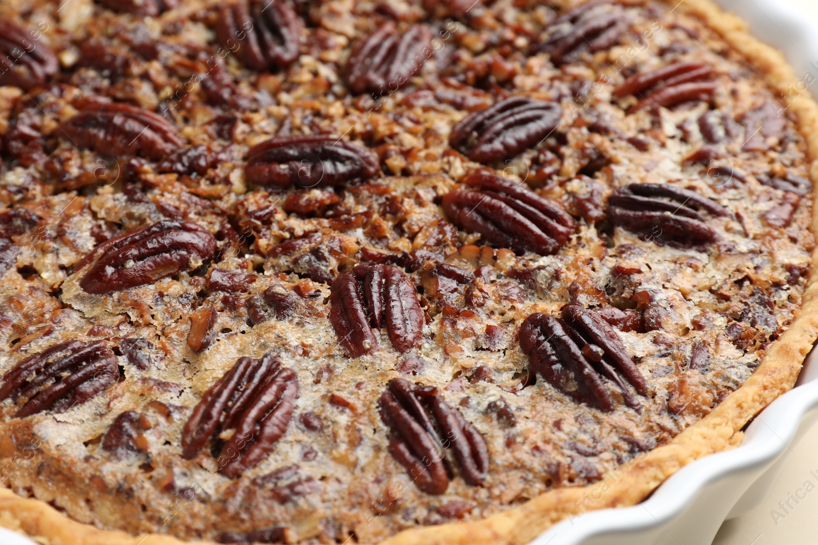 Photo of Delicious pecan pie in baking dish, closeup