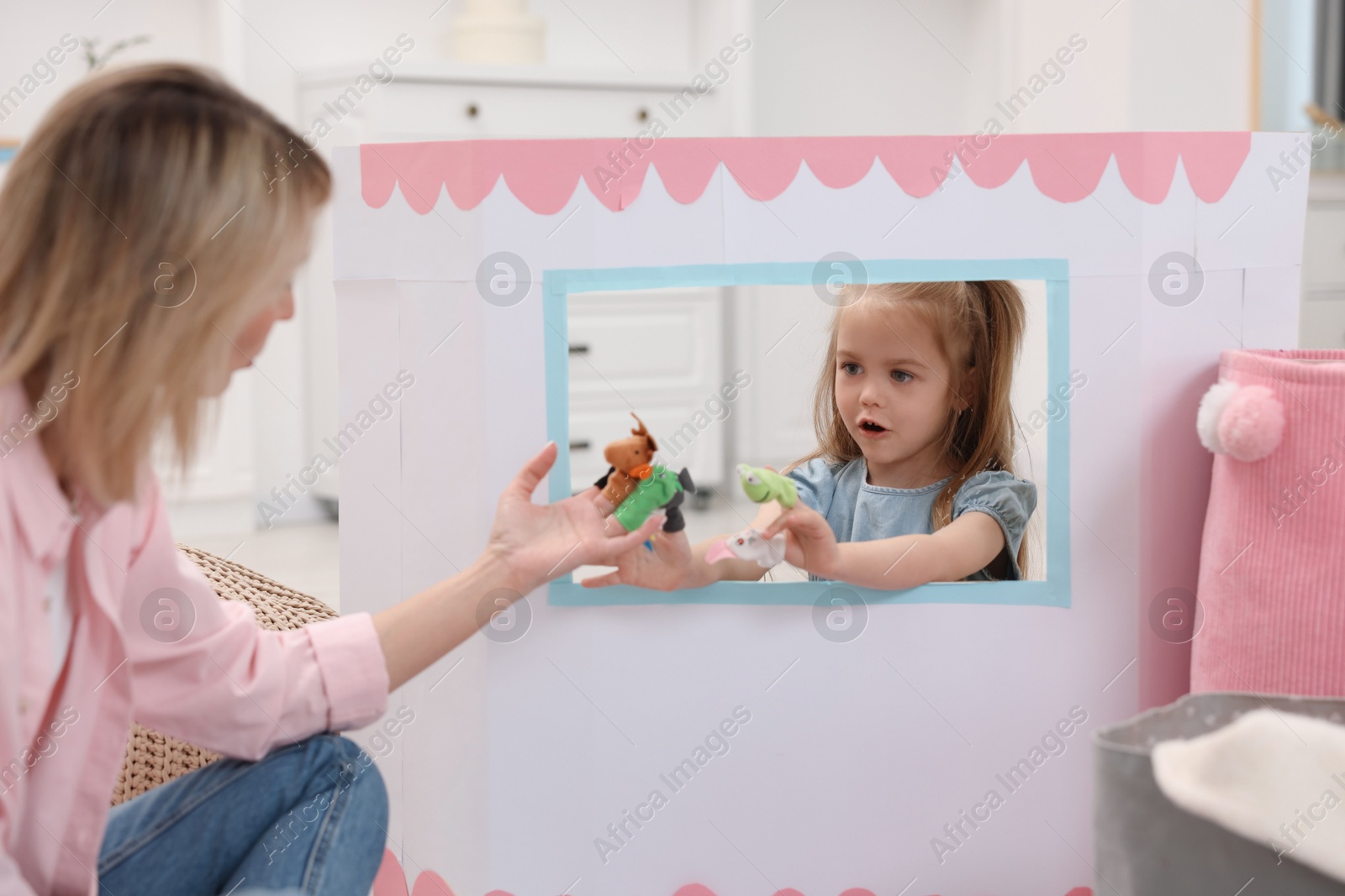 Photo of Puppet theatre. Mother and daughter performing show at home