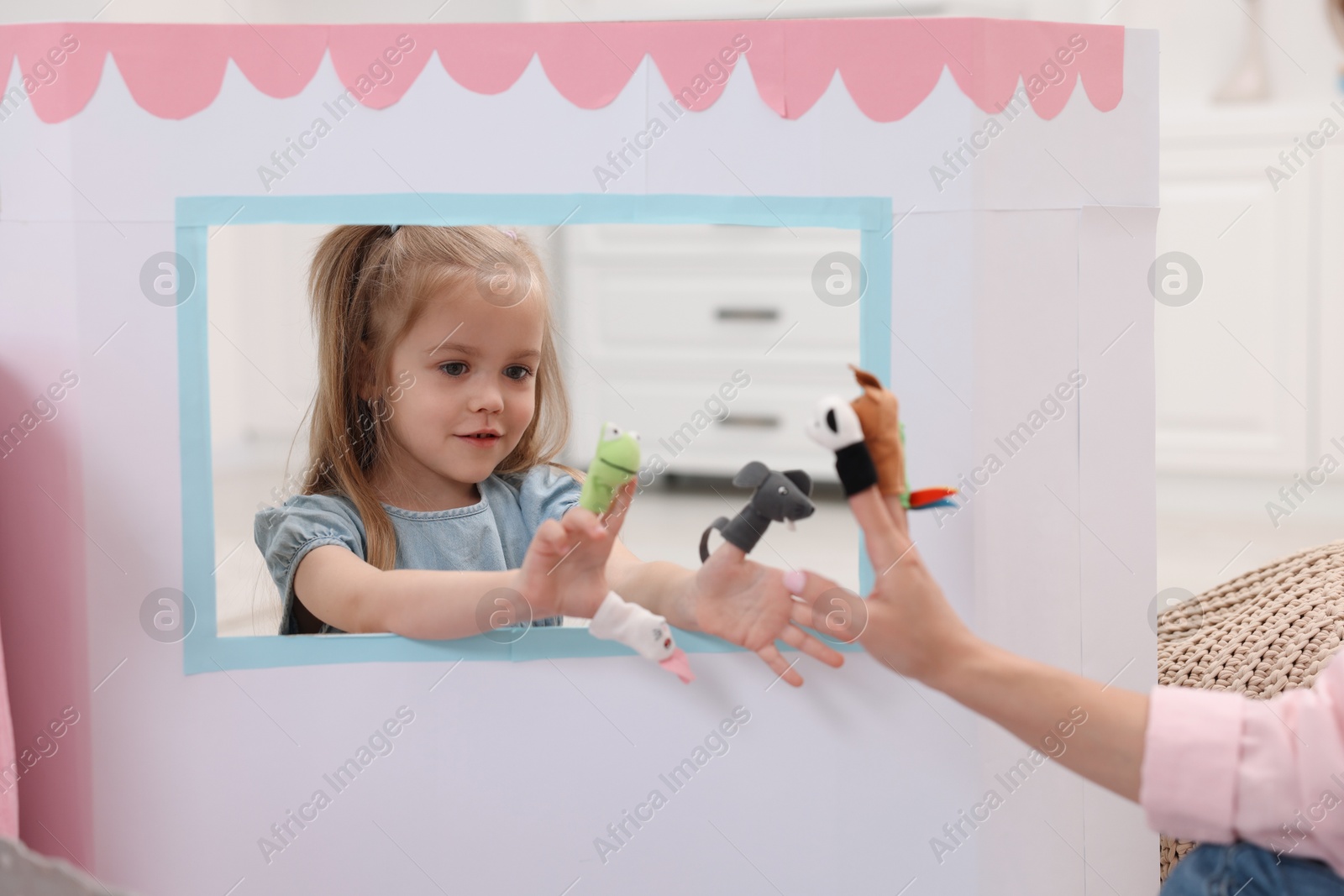 Photo of Puppet theatre. Mother and daughter performing show at home, closeup