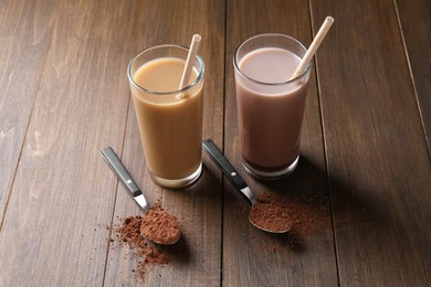 Photo of Delicious protein shakes in glasses and spoons with powder on wooden table