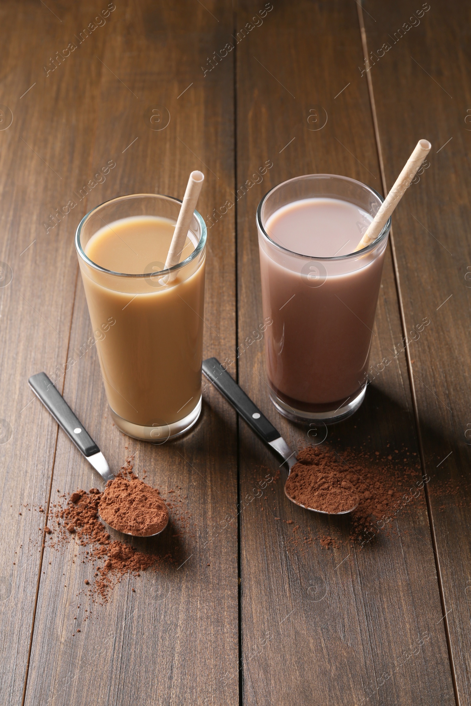 Photo of Delicious protein shakes in glasses and spoons with powder on wooden table