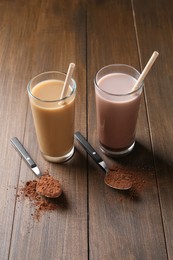 Photo of Delicious protein shakes in glasses and spoons with powder on wooden table