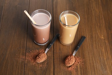 Photo of Delicious protein shakes in glasses and spoons with powder on wooden table