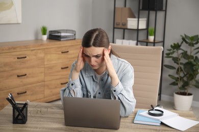 Photo of Embarrassed woman at wooden table with laptop in office