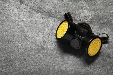 Photo of One respirator mask on grey table, top view. Space for text