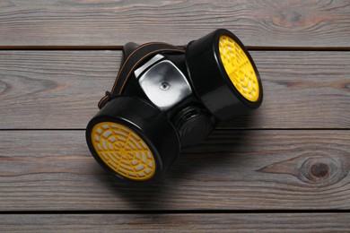 Photo of One respirator mask on wooden table, top view