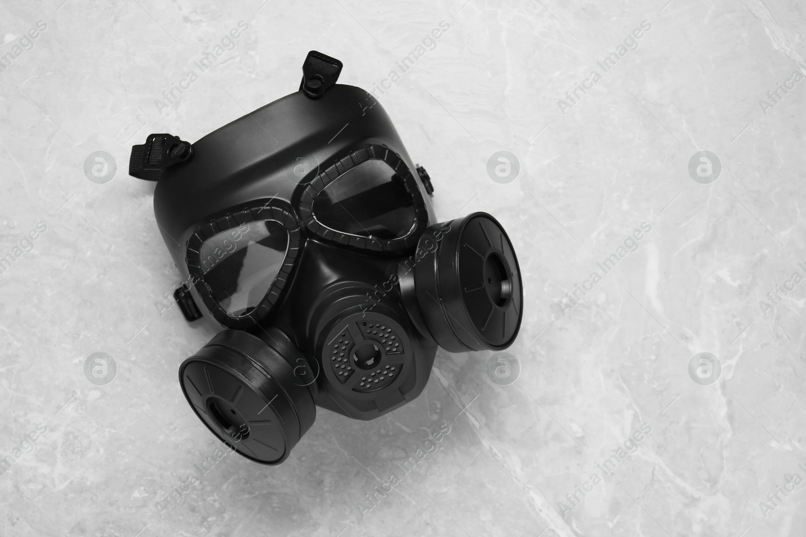 Photo of One gas mask on grey table, top view and space for text. Safety equipment