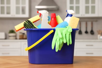 Cleaning service. Bucket with supplies on table in kitchen