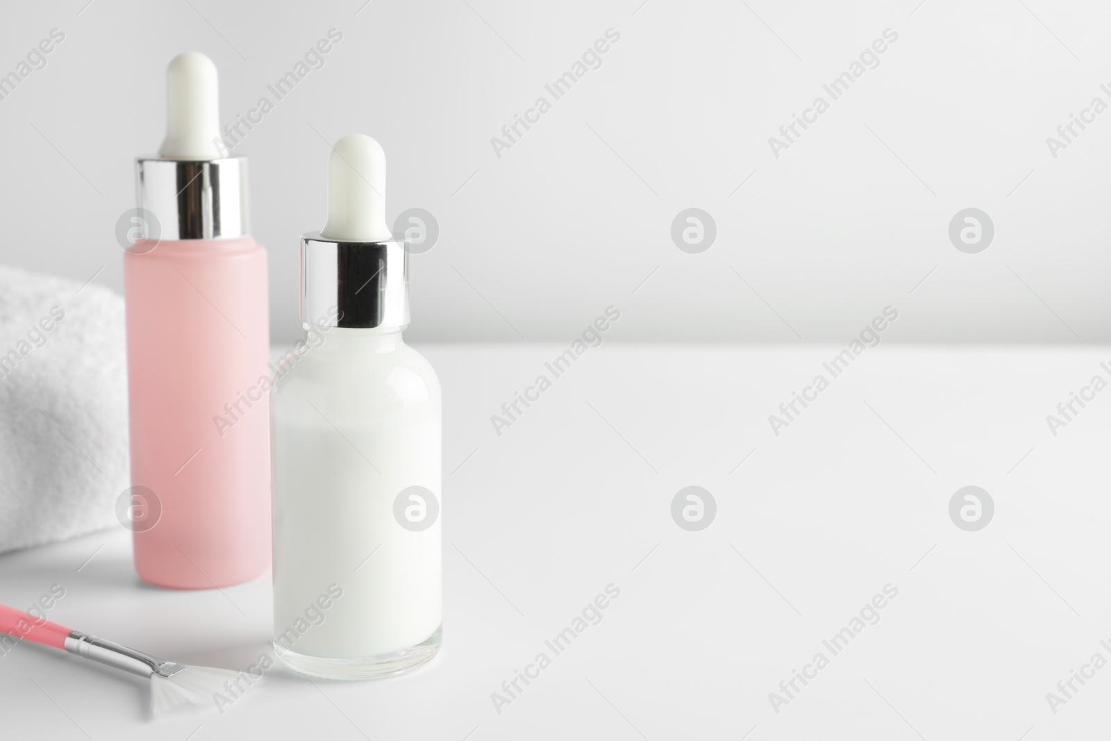 Photo of Bottles of chemical peel and brush on light background, space for text. Peeling procedure