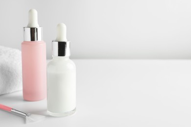 Bottles of chemical peel and brush on light background, space for text. Peeling procedure