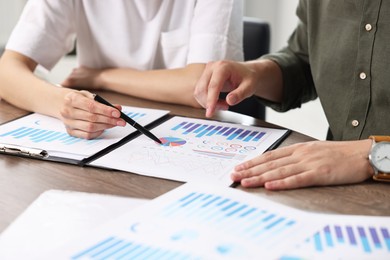 Consultant working with client at table in office, closeup