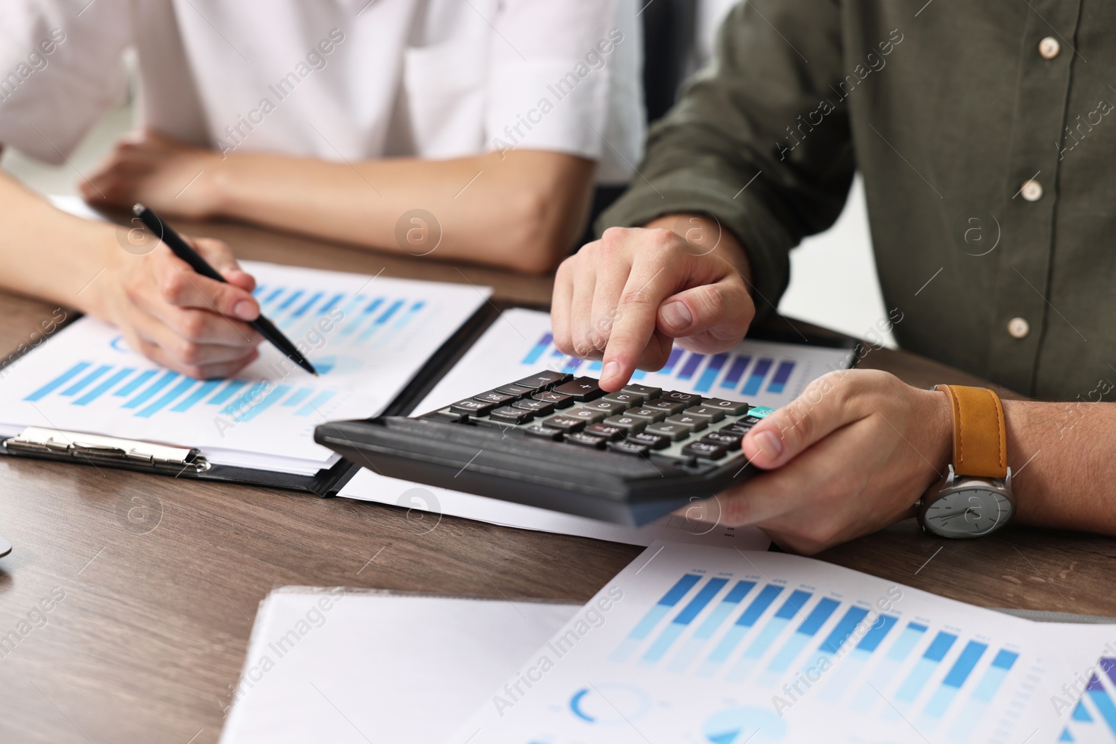 Photo of Consultant working with client at table in office, closeup