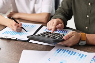 Photo of Consultant working with client at table in office, closeup