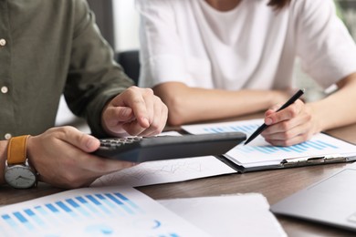 Photo of Consultant working with client at table in office, closeup