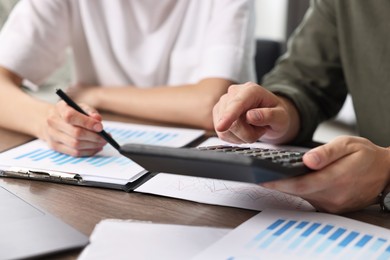 Photo of Consultant working with client at table in office, closeup