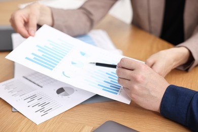 Photo of Consultant working with client at table in office, closeup