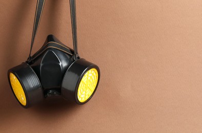 Photo of One respirator mask on brown background. Space for text