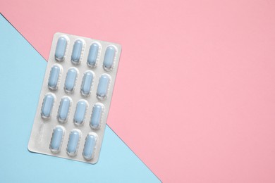 Photo of Antibiotic pills in blister on color background, top view. Space for text