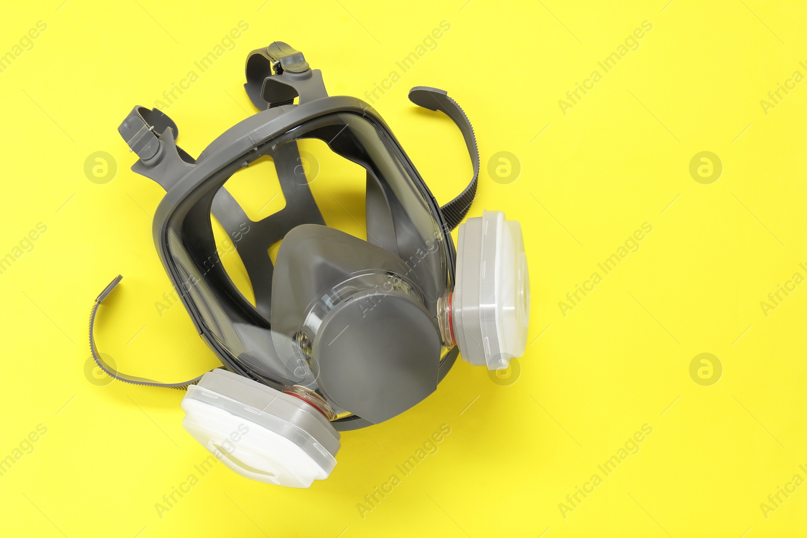 Photo of One full face respirator on yellow background, top view. Space for text