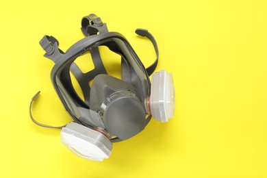 Photo of One full face respirator on yellow background, top view. Space for text