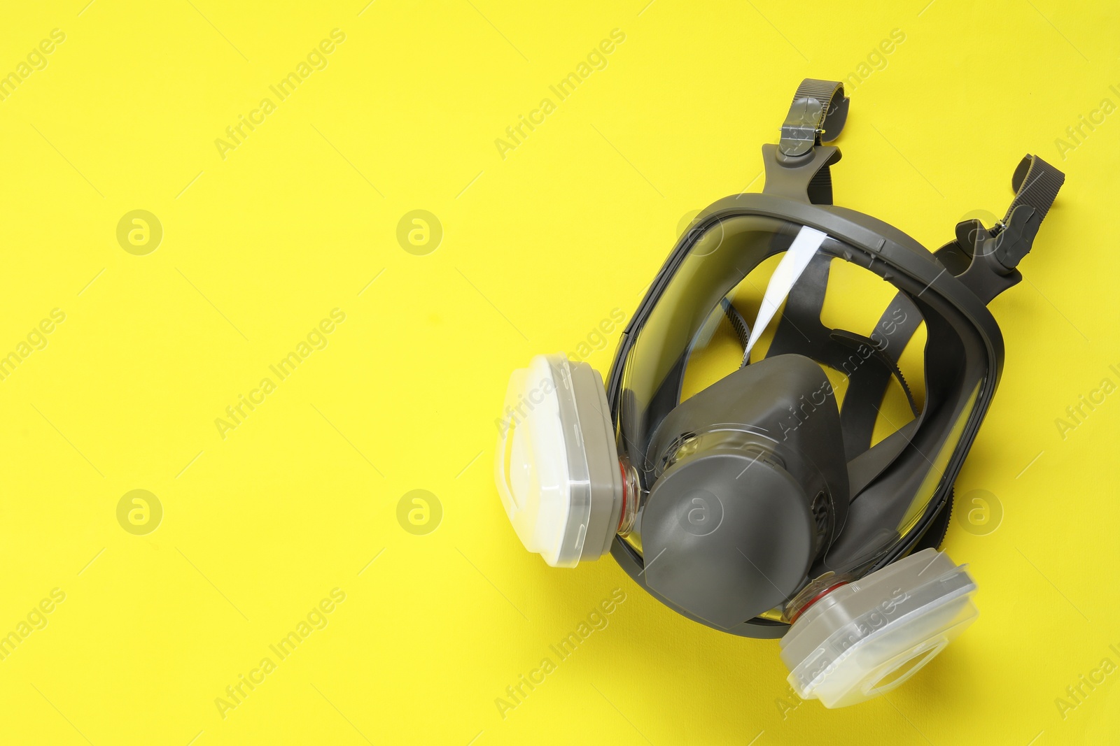 Photo of One full face respirator on yellow background, top view. Space for text