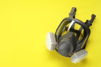 Photo of One full face respirator on yellow background, top view. Space for text