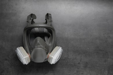 Photo of One full face respirator on dark textured table, top view. Space for text