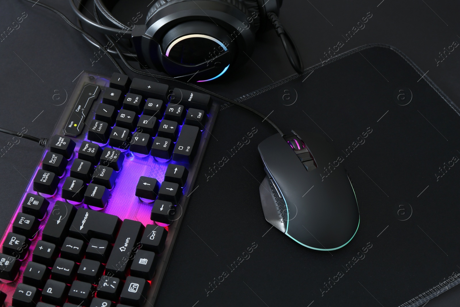 Photo of Computer mouse, RGB keyboard and headset on black background