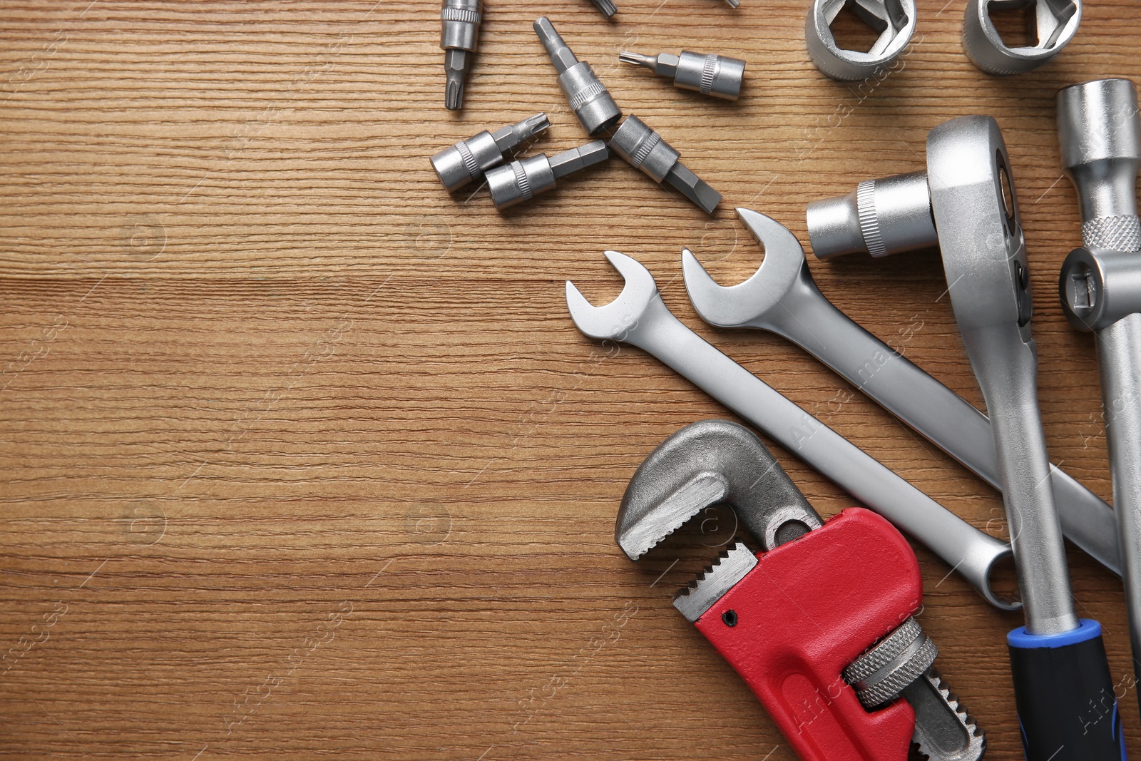 Photo of Different auto mechanic's tools on wooden table, flat lay. Space for text