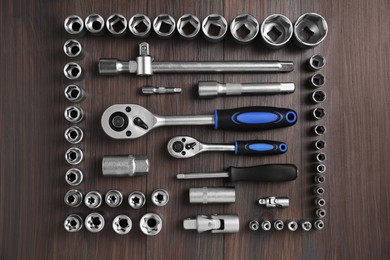 Different auto mechanic's tools on wooden table, flat lay