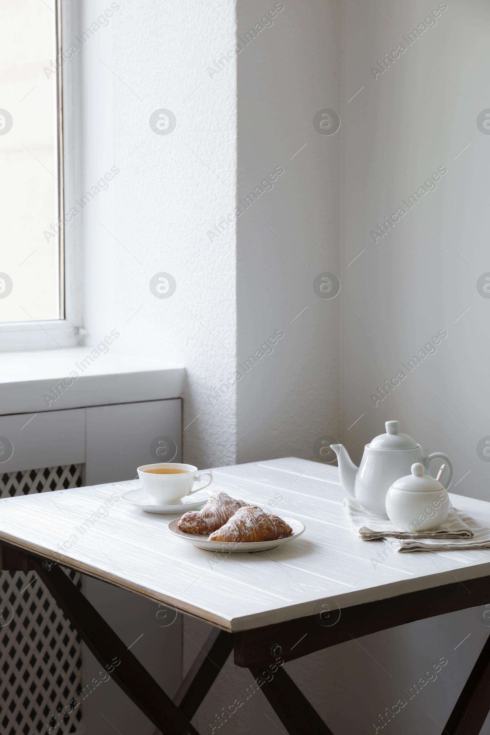 Photo of Croissants and tea on table in studio. Professional food photography