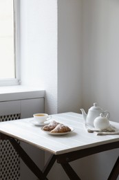 Croissants and tea on table in studio. Professional food photography