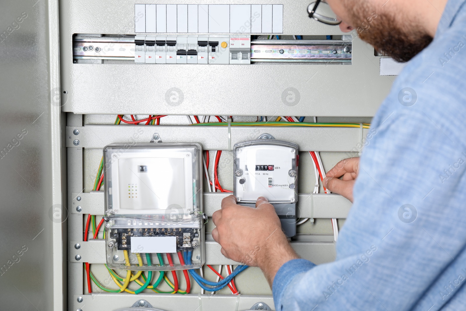 Photo of Man checking electricity meter indoors, closeup view