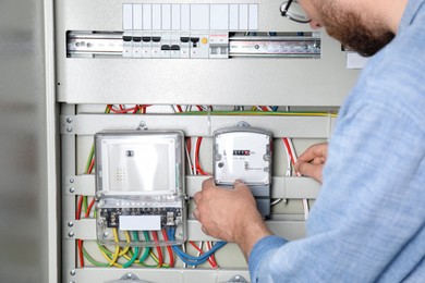 Man checking electricity meter indoors, closeup view